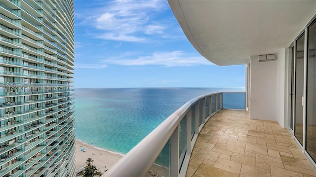 balcony featuring a water view and a beach view