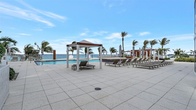 view of pool featuring a water view, a gazebo, and a patio area