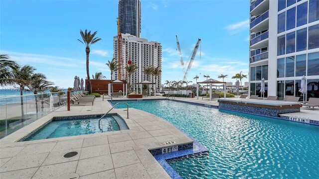 view of pool with a gazebo, a community hot tub, a patio, and a water view