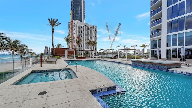 view of pool with a gazebo, a community hot tub, a patio, and a water view