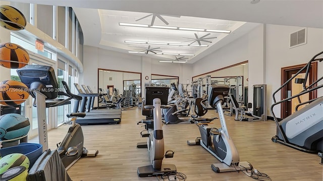 exercise room featuring a high ceiling and light wood-type flooring