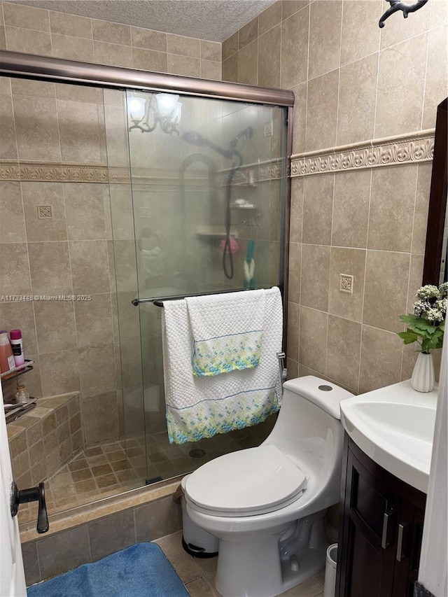 bathroom with tile walls, tile patterned flooring, an enclosed shower, vanity, and toilet