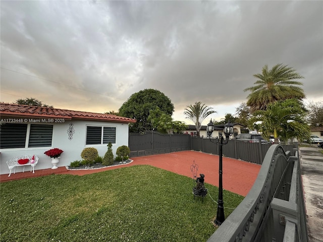 yard at dusk featuring a patio area