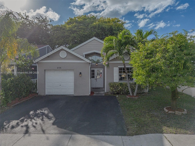 view of front of home with a garage, aphalt driveway, and stucco siding