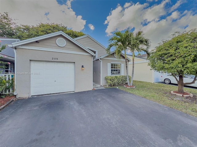 ranch-style home featuring aphalt driveway, an attached garage, a front yard, and stucco siding