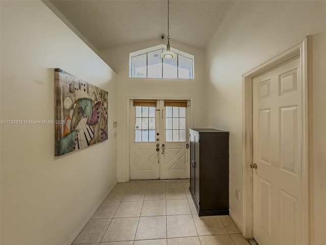 entryway with vaulted ceiling, light tile patterned floors, a textured ceiling, and french doors