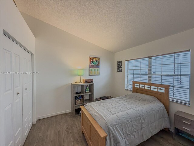 bedroom with vaulted ceiling, wood-type flooring, access to outside, ceiling fan, and a textured ceiling