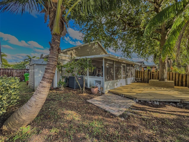 back of house featuring cooling unit, a deck, and a sunroom