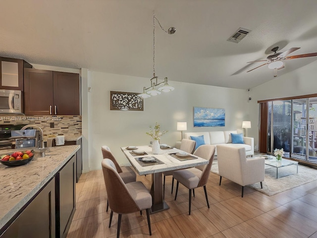 dining area with ceiling fan, lofted ceiling, and sink