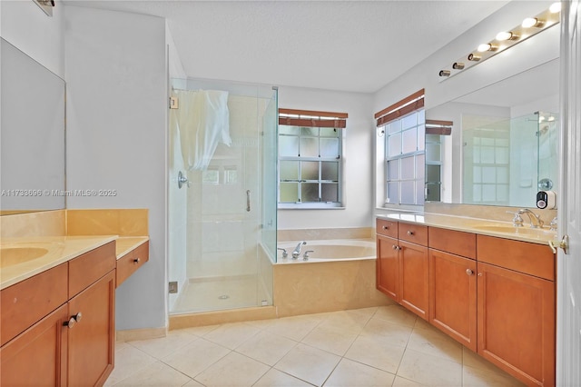 bathroom with vanity, separate shower and tub, tile patterned flooring, and a textured ceiling