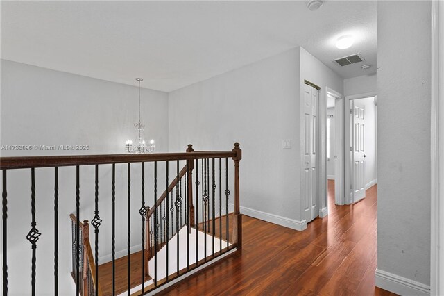 hallway featuring dark hardwood / wood-style flooring and a chandelier