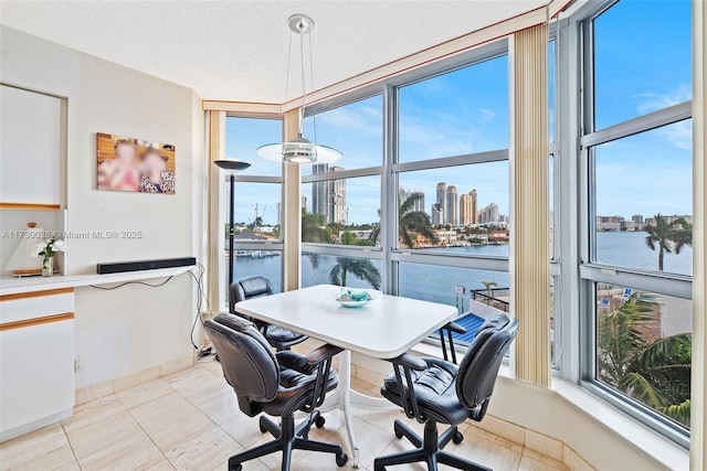 dining room with expansive windows, a textured ceiling, and a water view