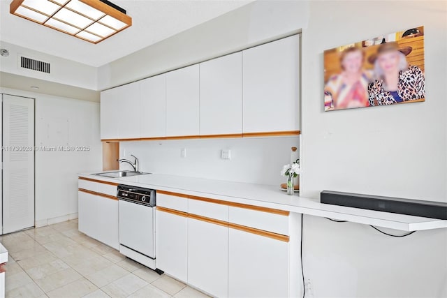 kitchen featuring sink, white cabinets, and white dishwasher