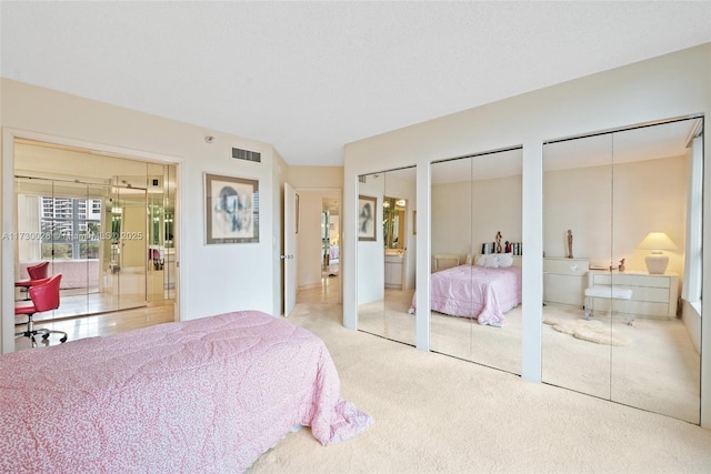 carpeted bedroom featuring multiple closets and french doors