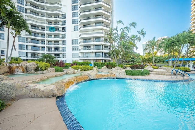 view of swimming pool featuring pool water feature and a hot tub