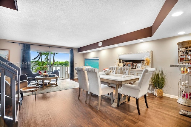 dining area featuring hardwood / wood-style flooring and a textured ceiling