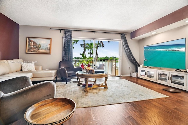 living room featuring wood-type flooring and a textured ceiling