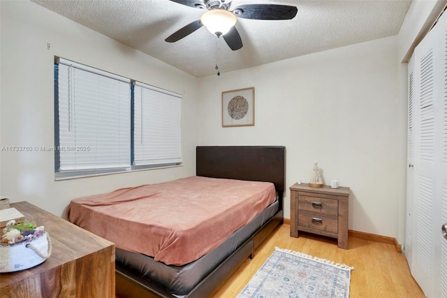 bedroom with a closet, a textured ceiling, ceiling fan, and light hardwood / wood-style floors