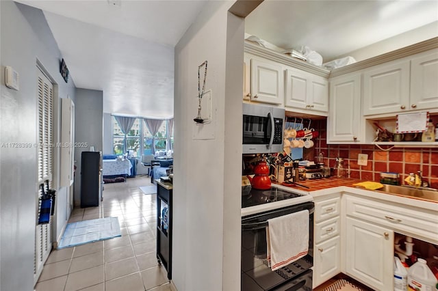 kitchen featuring sink, decorative backsplash, cream cabinetry, and light tile patterned flooring