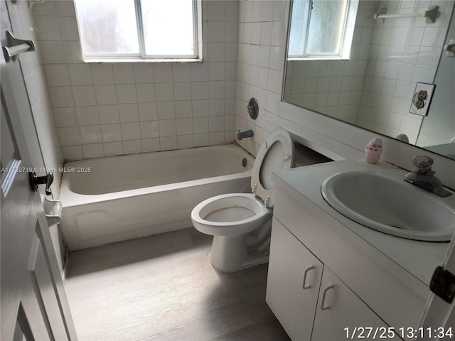 full bathroom with tiled shower / bath combo, vanity, plenty of natural light, and toilet