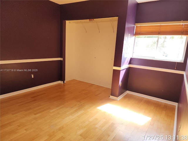 unfurnished bedroom featuring wood-type flooring and a closet