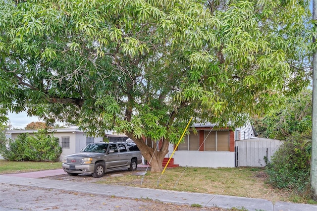 view of front of property featuring a sunroom and a front yard