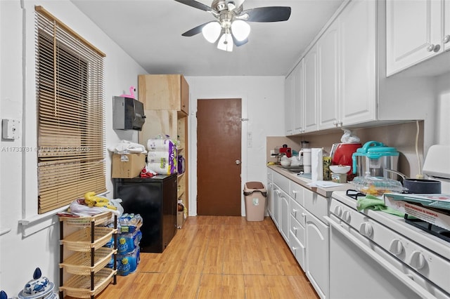 kitchen featuring light hardwood / wood-style flooring, white cabinets, ceiling fan, and white gas range oven