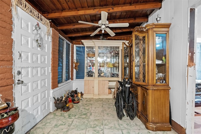 interior space featuring ceiling fan, wood ceiling, and beamed ceiling