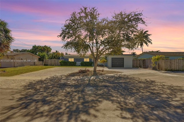 2720 SW 19th St, Fort Lauderdale, FL 33312 - view of front facade with dirt driveway, fence, an attached garage, and stucco siding