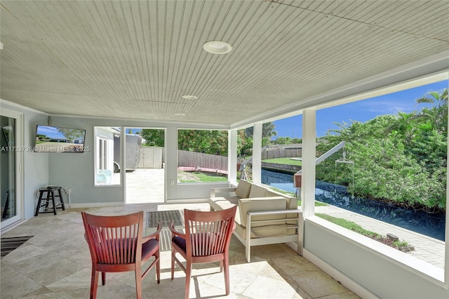 sunroom / solarium featuring a water view