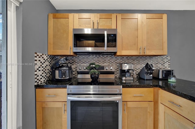 kitchen featuring appliances with stainless steel finishes, light brown cabinetry, decorative backsplash, and dark stone countertops