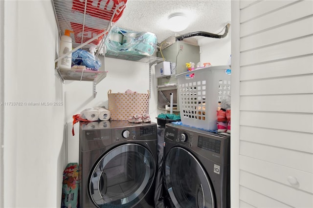 laundry area with separate washer and dryer and a textured ceiling