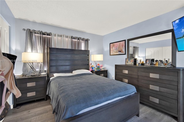 bedroom with hardwood / wood-style flooring and a textured ceiling