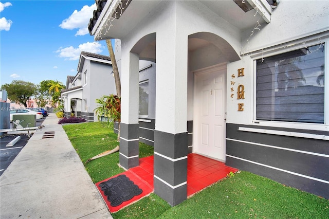 doorway to property with a lawn