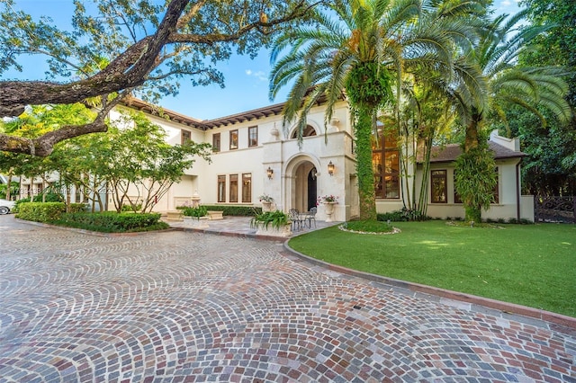 mediterranean / spanish home featuring a front lawn