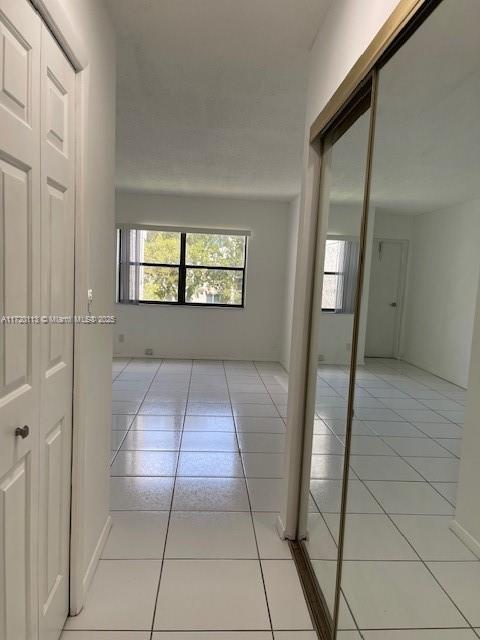 hall featuring light tile patterned flooring