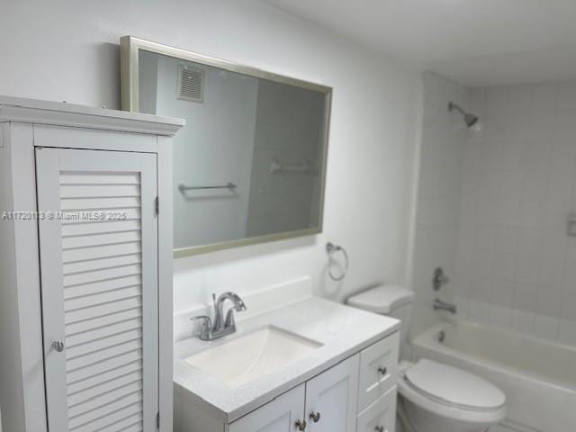 full bathroom featuring vanity, tiled shower / bath combo, and toilet