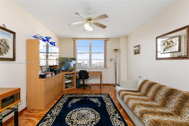 tiled office with a textured ceiling and ceiling fan