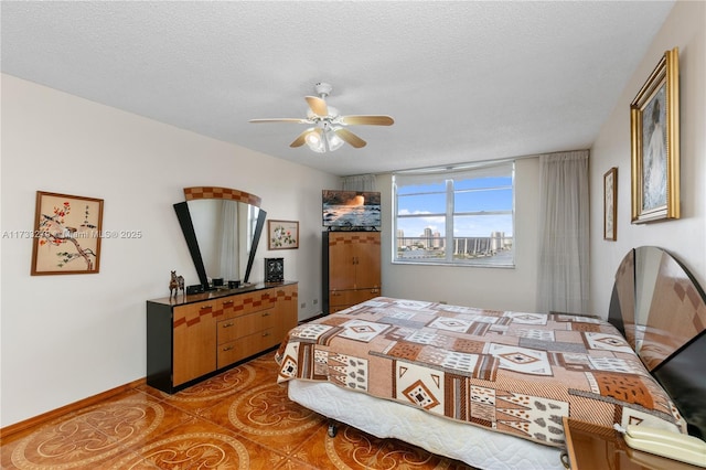 bedroom featuring light tile patterned floors, a textured ceiling, and ceiling fan