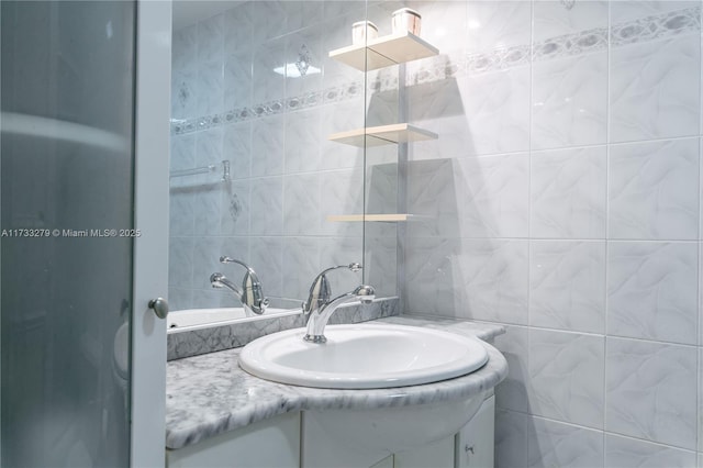 bathroom with vanity and tile walls