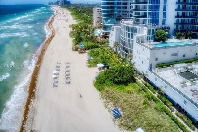 drone / aerial view featuring a water view and a view of the beach