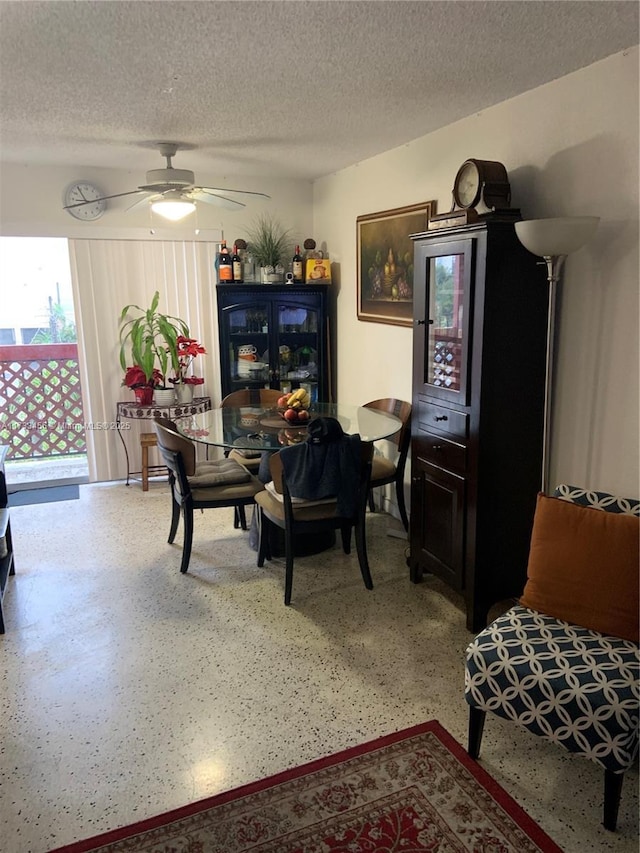 dining room featuring ceiling fan and a textured ceiling