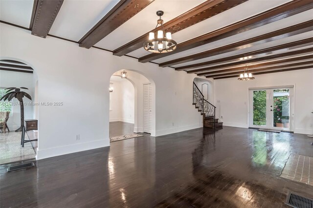 interior space featuring dark hardwood / wood-style flooring, a notable chandelier, beam ceiling, and a wealth of natural light