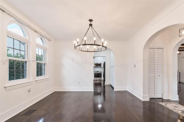 unfurnished dining area featuring dark hardwood / wood-style floors and a chandelier