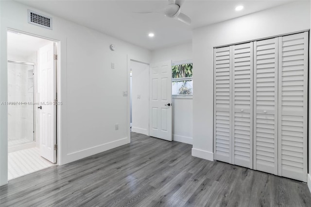 unfurnished bedroom with dark hardwood / wood-style floors, connected bathroom, ceiling fan, and a closet