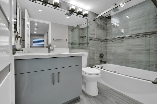 full bathroom featuring toilet, vanity, and shower / bath combination with glass door