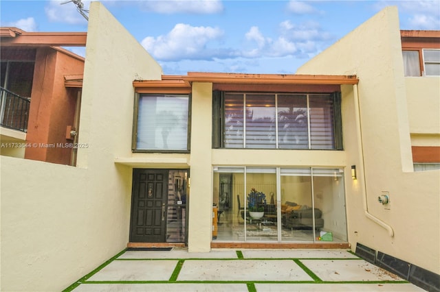 back of property featuring a patio and stucco siding