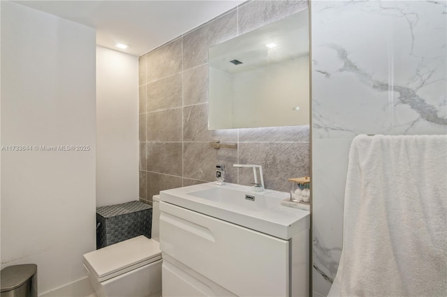 bathroom featuring backsplash, tile walls, and vanity