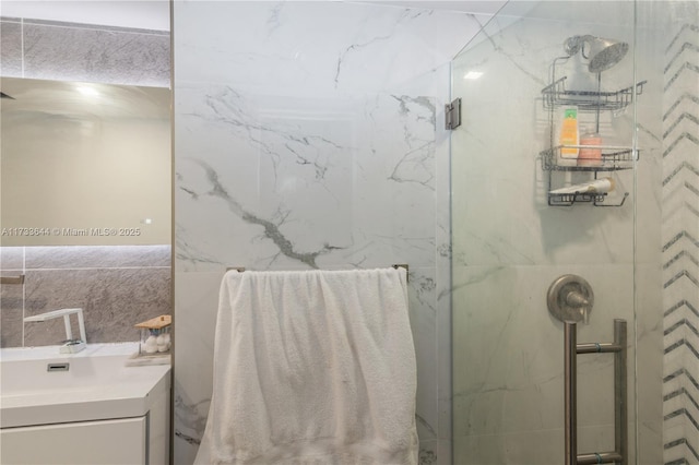 full bath featuring vanity and a marble finish shower