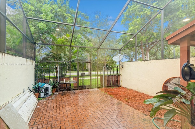 view of patio featuring a lanai and fence